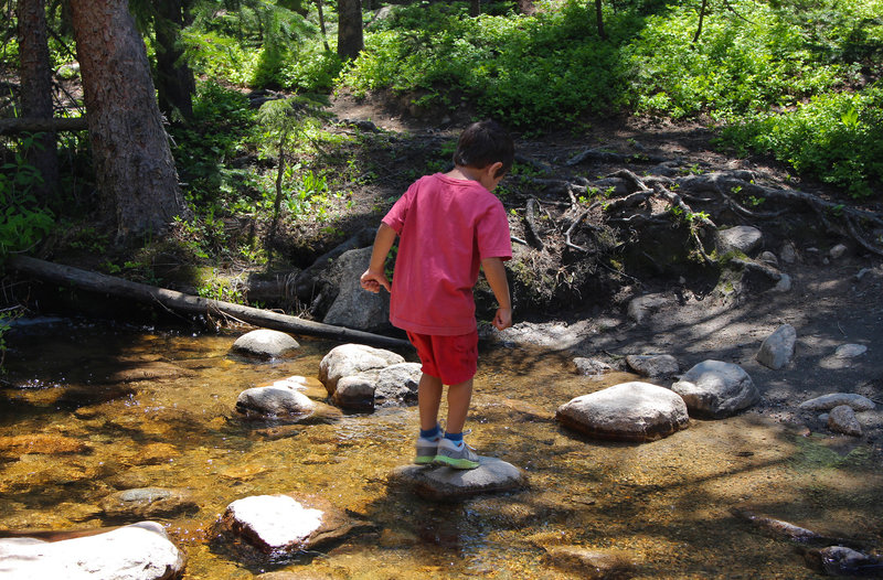 Alex hops across a creek