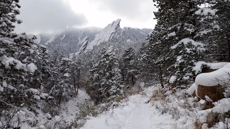 A snowy start of the Mesa Trail looking at the first Flatiron.