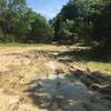 Muddy open lot at the start of the Flat Rock Trail