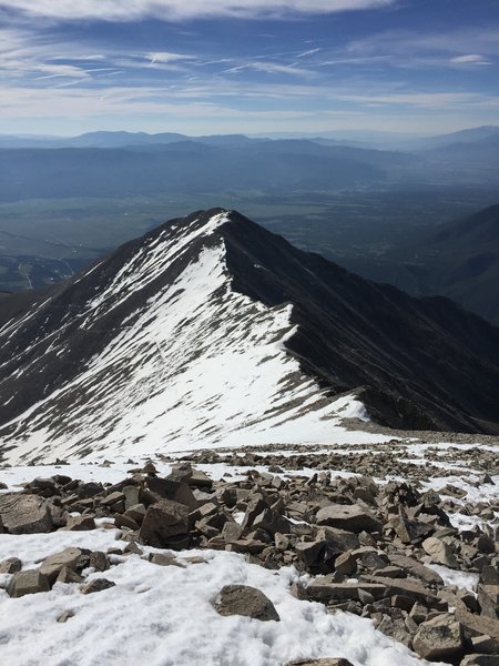 The route, seen from just below the summit. The switchbacks on the trail are covered with snow, so the path is slightly different with summer conditions. Tigger Peak and the Arkansas Valley are seen in the foreground.