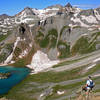 Descending Grant/Swamp Pass to Ice Lakes Basin. Island Lake, is below and Fuller Peak, Vermillion Peak and Golden Horn stand tall in the distance.