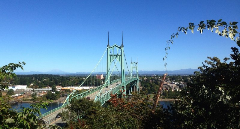 The lower end of the Ridge Trail offers a stunning view of the St. Johns Bridge and the Cascade Range. Mt. St. Helens can be seen on the left side of the bridge and Mt. Adams on the right.