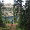 Descent through a pine forrest with majestic and stunning views of Snowmass Lake.