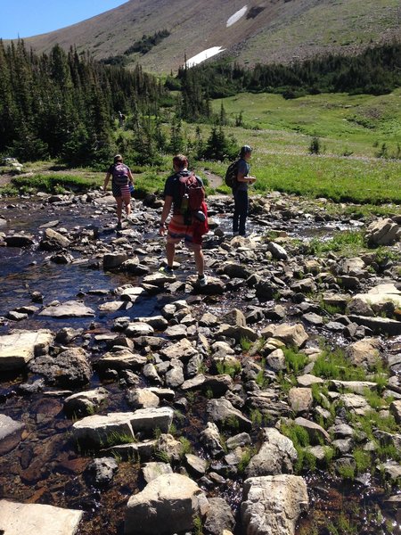 Hopping across some rocks on a beautiful day on Siyeh Pass!