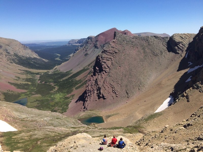 Three friends taking a minute to take in the view from the summit of Siyeh Pass.