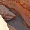 From the left side, looking down on the boulder blocking the entrance.