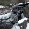 The small waterfall adorned with snow and ice.