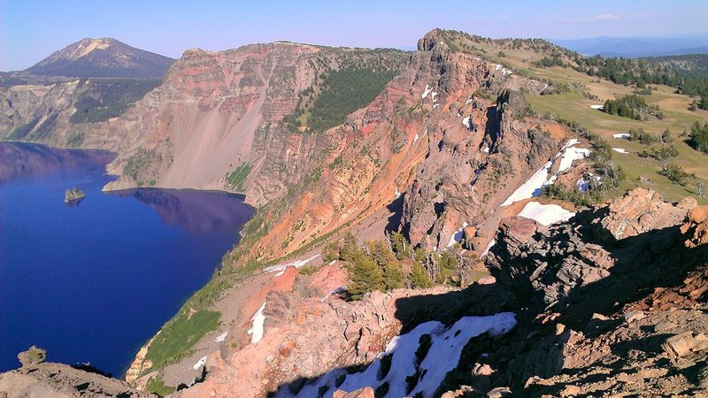 Alpine meadows blanket Mt. Mazama's south slope right up to the rim. Below, Phantom Ship rises from the impossibly blue waters of Crater Lake.