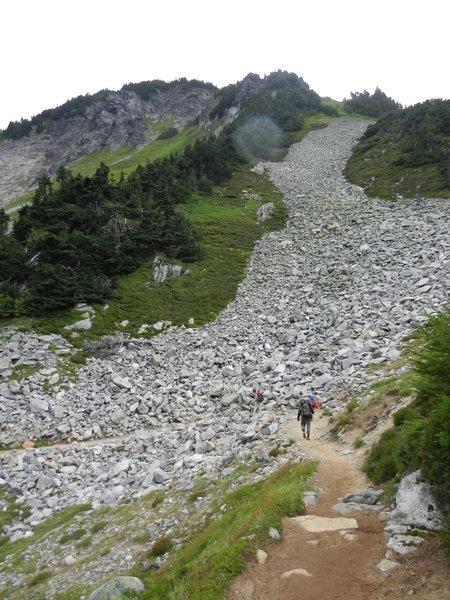 Hikers crossing the talus slope on the way to Cascade Pass.