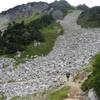 Hikers crossing the talus slope on the way to Cascade Pass.