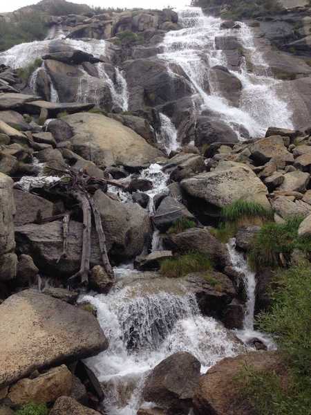 A cascade that is crossed by a small wooden footbridge, on the way up to Dusy Basin or down to LeConte Canyon (depending on the direction of travel).