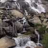 A cascade that is crossed by a small wooden footbridge, on the way up to Dusy Basin or down to LeConte Canyon (depending on the direction of travel).