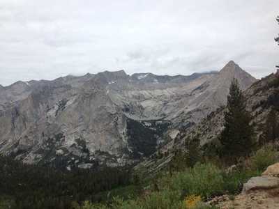 A view from the Bishop Pass Trail of a large cirque, with Langille Peak  being the pointy one on the right, and the Black Divide in the background.