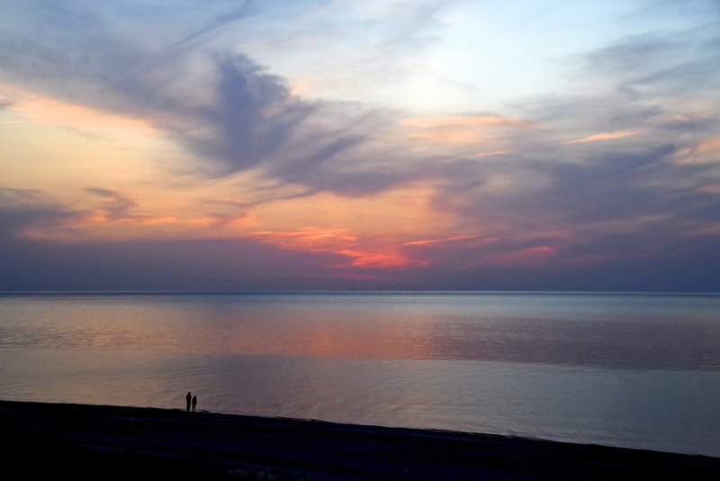 A couple enjoying the incredible colors of the Lake Michigan sunset.