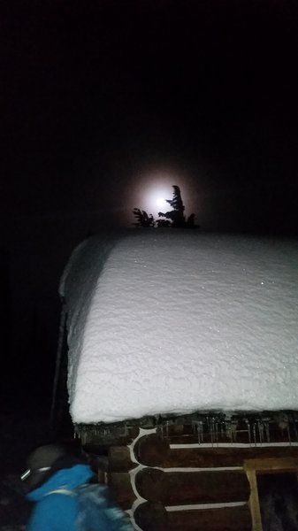 A full moon peeps out over a lean-to on an evening hike to Mt. Kit Carson.