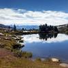 Small alpine lake along Isberg Trail with the Silver Divide and John Muir Wilderness high country in the distance.