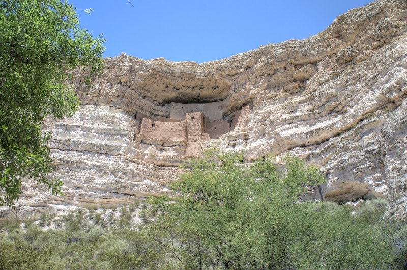 Montezuma's Castle can be seen high above the lush green valley below Montezuma's Well.