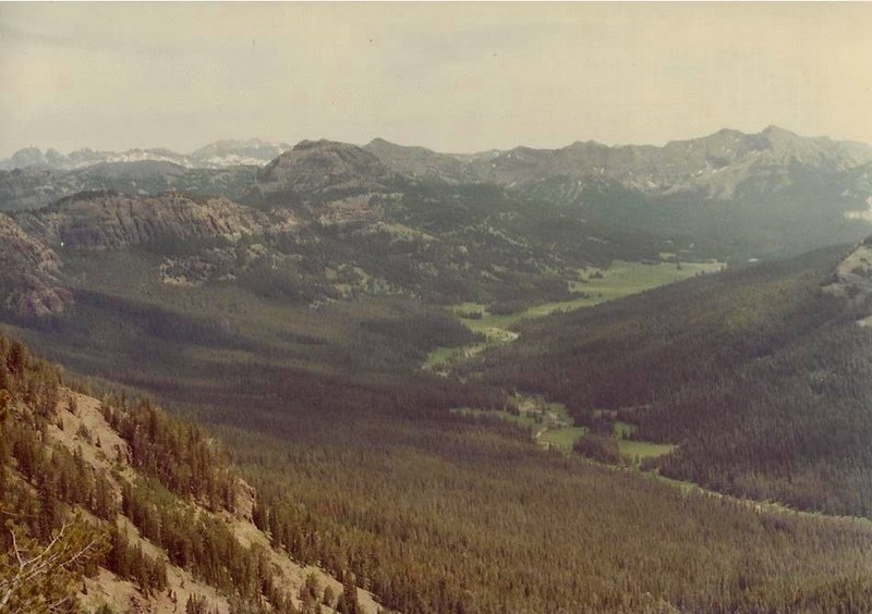 From Bliss Pass the rare beauty of Upper Pebble Creek spreads out at your feet. Beyond the park boundary the granite peaks of the snowy Beartooth Mountains loom in the distance.