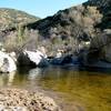 Seasonal swimming hole and waterfall at the south end.