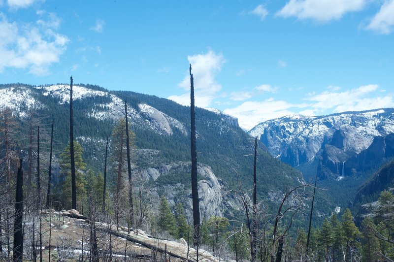 The view toward Yosemite Valley. El Capitan peeks above the ridge line, and Bridalveil Falls can be seen on right hand side.