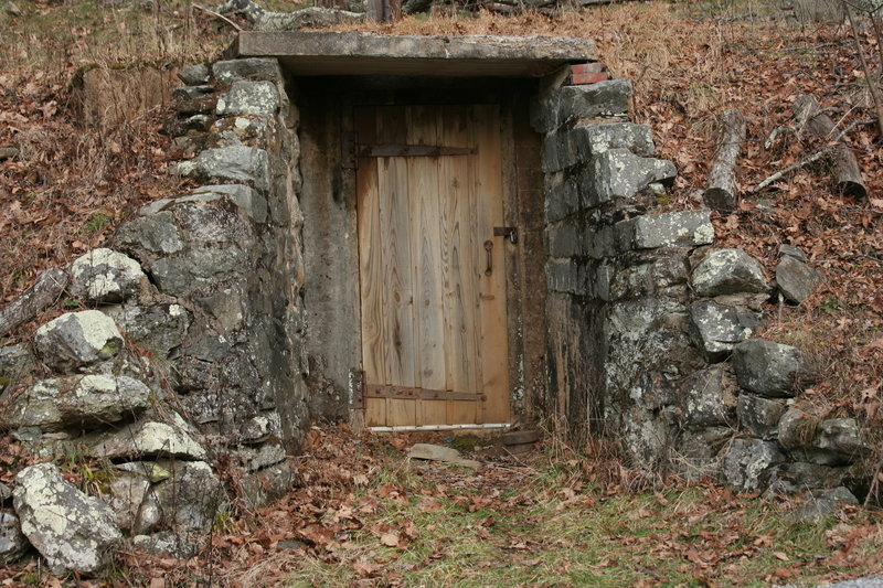 A door in the side of the hill, and behind it is a pump that sends most of the output of Lewis Spring up to the underground storage tanks on Blackrock.