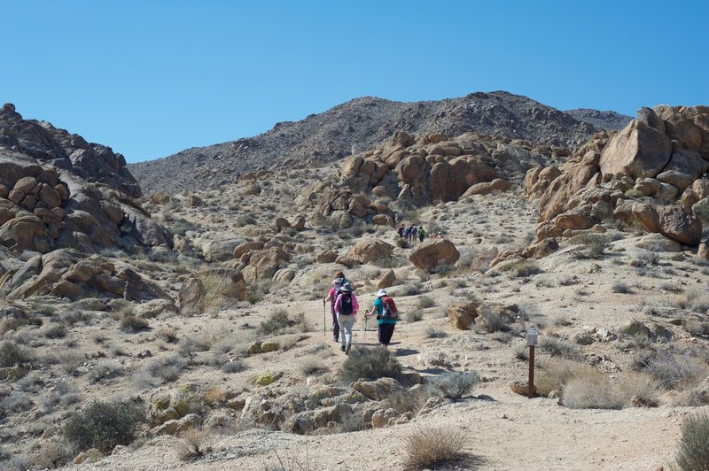 The hike starts climbing immediately past large boulders on both sides of the trail.