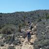 Hikers pass through the saddle and continue the ascent to the summit of the mountain.