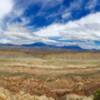 Panoramic view of the valley below and the Henry Mountains in the distance.