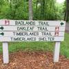 Signage for the Timberlakes Shelter parking lot and the three loop trails.