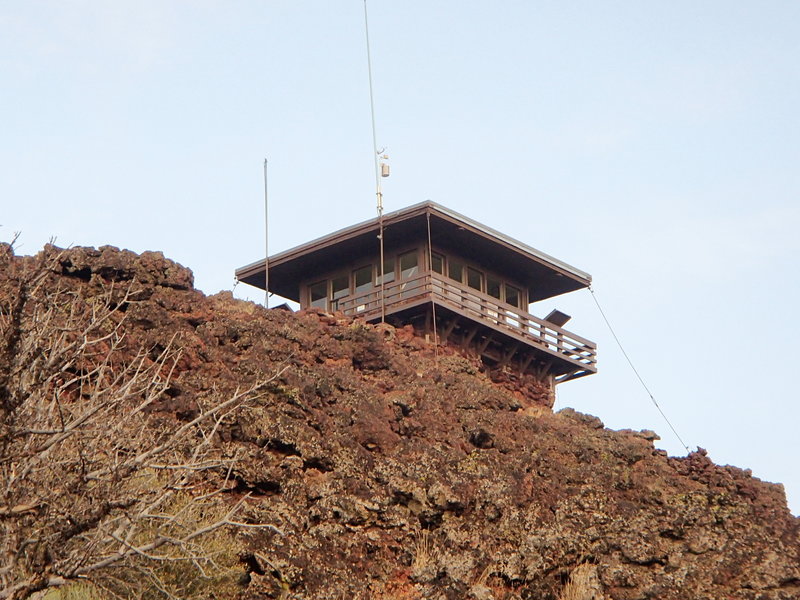 The fire lookout sits at the summit atop lava splatters.