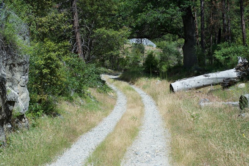 The trail becomes a two gravel tire tracks after the bridge.