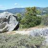 The trail breaks off to the right of the weather station and passes on the right side of this rock.