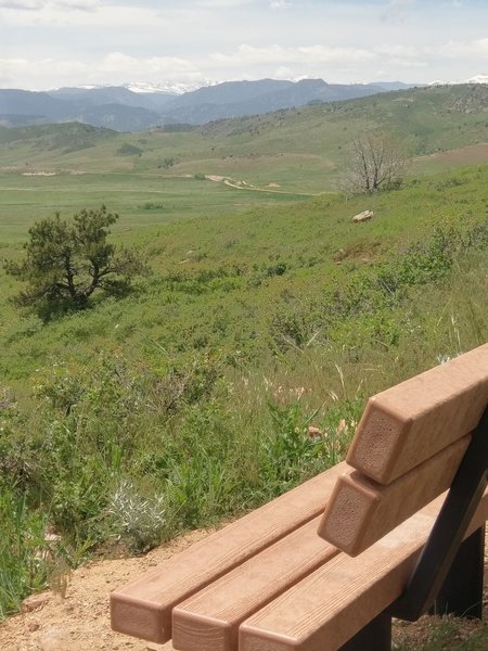 Snowy peaks in the distance from this well-placed bench.