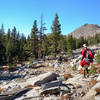 Hikers picking their way through a small boulder field along the PCT.