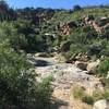 The trail winds around the hillside and enters into the wash. From here you make your way up the slick rock to the falls.