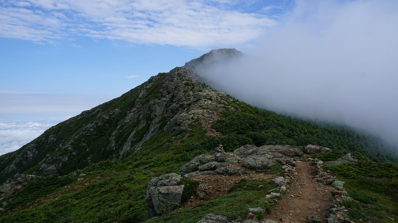 The summit of Mt. Lafayette looms out of the clouds ahead.