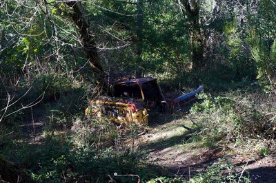 An old, abandoned truck sits off to the side of the trail.