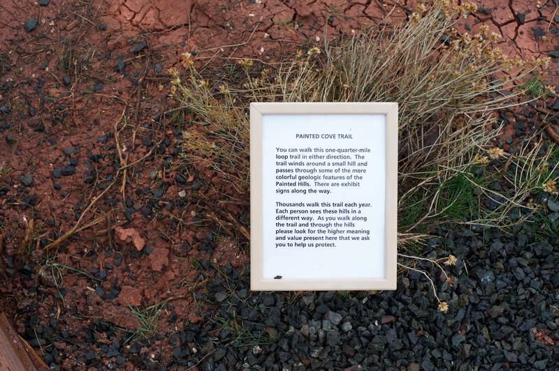 A sign urging visitors to stay on the trail.