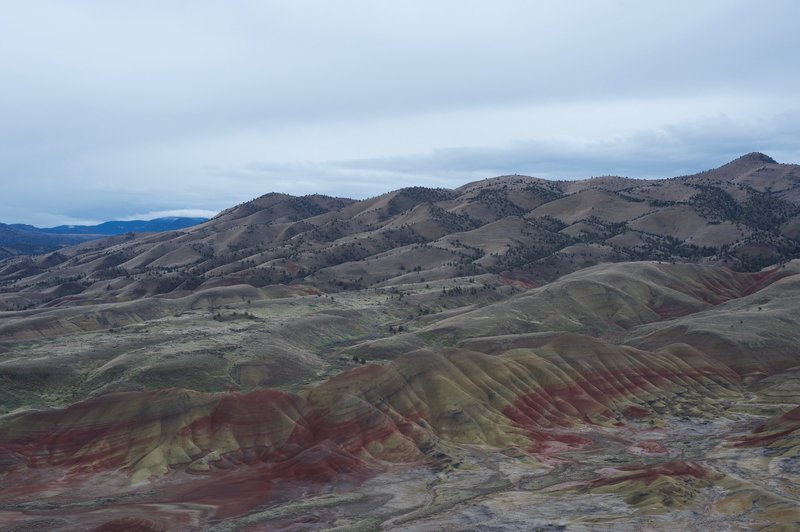 The pained hills and surrounding hills stretch out before you.