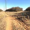 Follow the power line road trail to your left to the end, to rejoin the green singletrack.