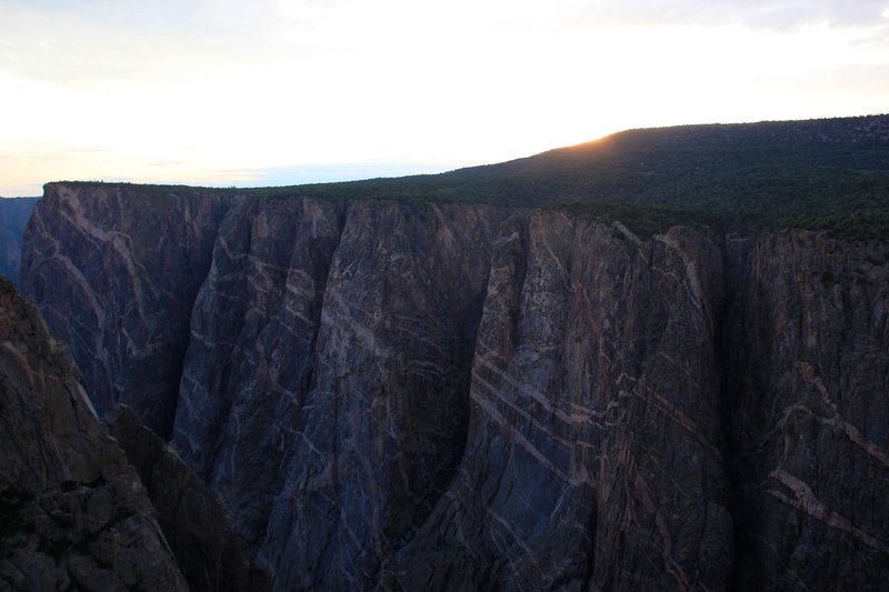 While the sun hides behind the cliff, the precambrian rocks shine.