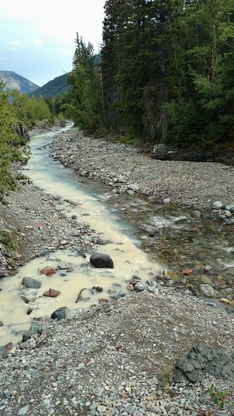 Red Rock Creek, milky with silt, joins the clear Bauerman Creek.