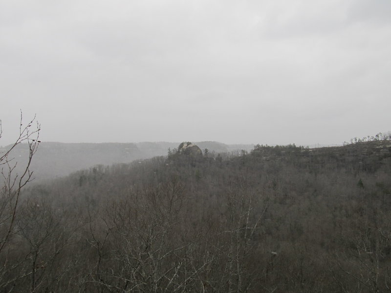 Courthouse Rock looms from the top of Double Arch in some windy snow flurries.