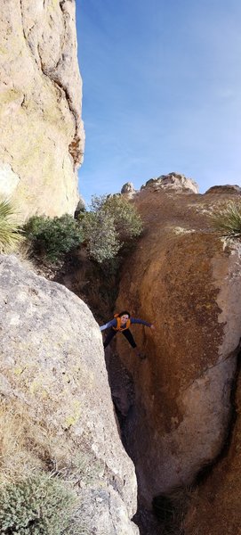 A hiker navigates the steep-walled slots above La Cueva.