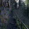 The trail follows the rock face of the cliff as it makes its way toward the falls. This is looking back down the trail.