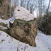 A large boulder rests beside the trail.