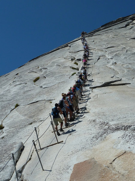 The infamous cable climb on Yosemite's Half Dome rewards visitors with stunning views from the top.