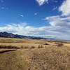 Looking north from the Sharptail Ridge Trail, you'll see phenomenal views of the Front Range. The trailhead barn can be seen below (with a green roof).