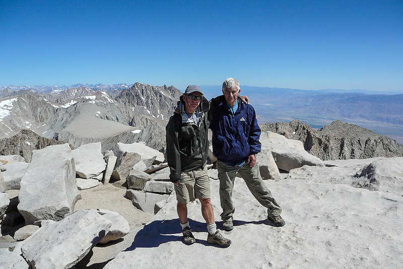 Tired and happy to be on the summit of Mt. Whitney, a pair of hikers enjoys their accomplishment.