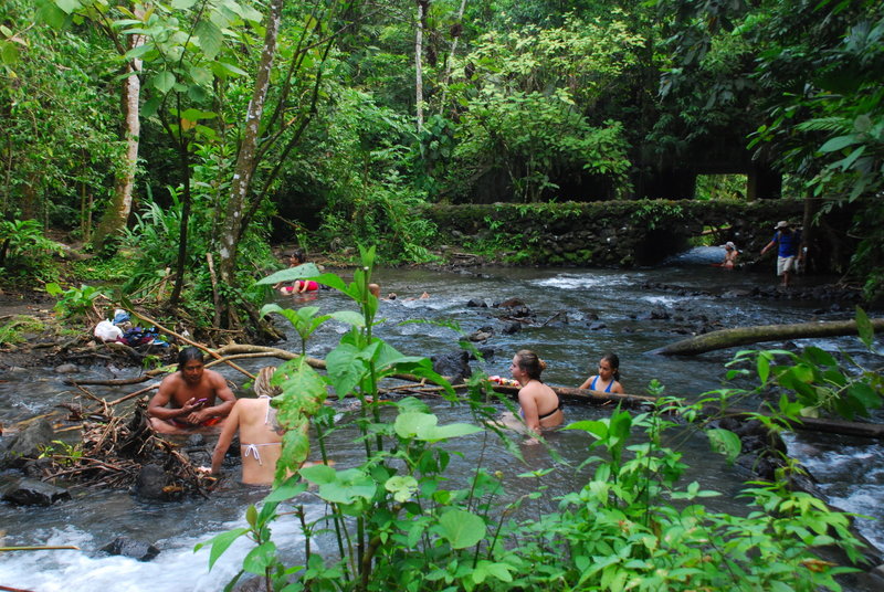 Friends soak in the natural hot springs near Tabacon.